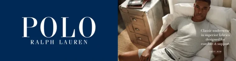 A wide retail web banner: a navy panel carrying the brand wordmark beside a photograph of a model in a white t-shirt and grey shorts sitting on a bed, with a shop-now link.