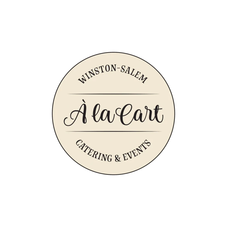 A circular identity badge on black: "À la Cart" in dark script on a cream disc, inside a ring lettered Winston-Salem above and Catering & Events below, divided by hairline rules.