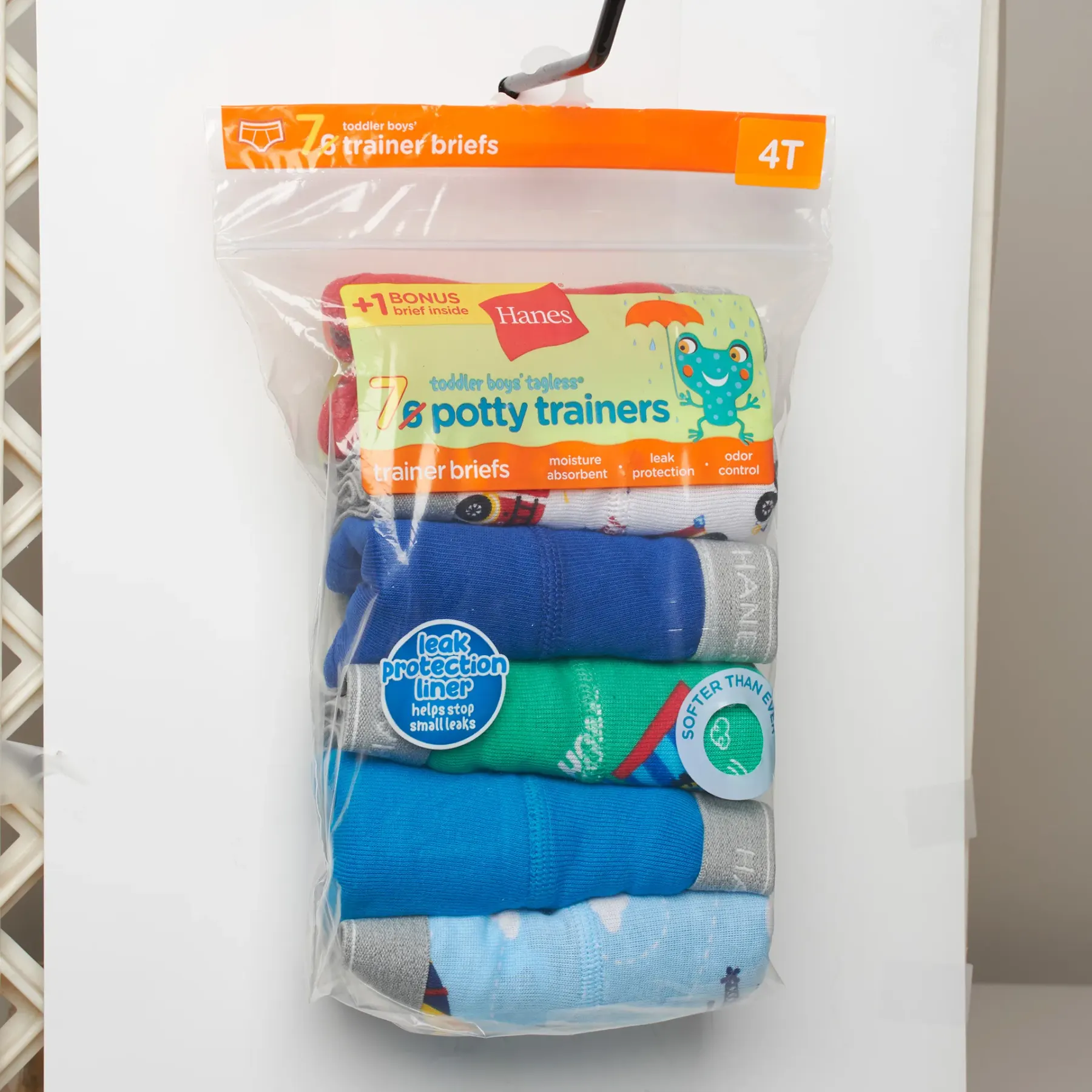 The same pack as shot hanging on a wire shop rack, the bag creased and tilting, with a 4T size tab clipped above it.