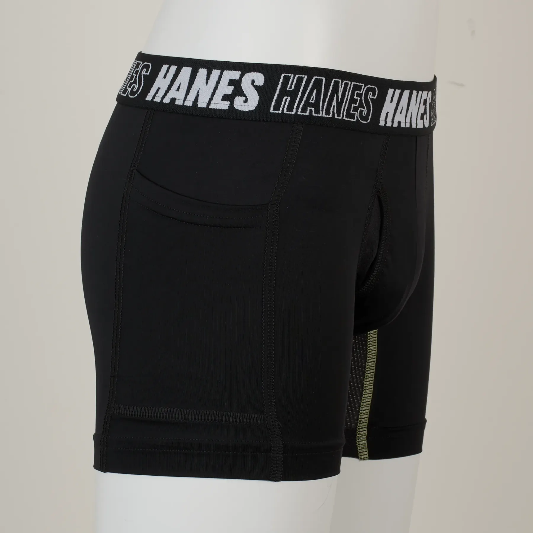 The same garment as shot on a white display form against a grey wall, the leg openings collapsing where the form ends.